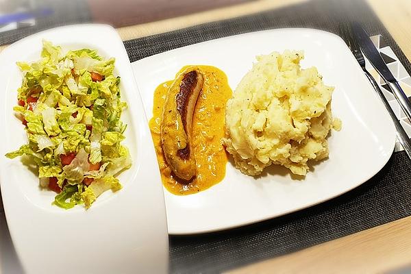 Thuringian Rostbratwurst on Curry Cream Sauce with Mashed Potatoes and Romaine Tomato Salad